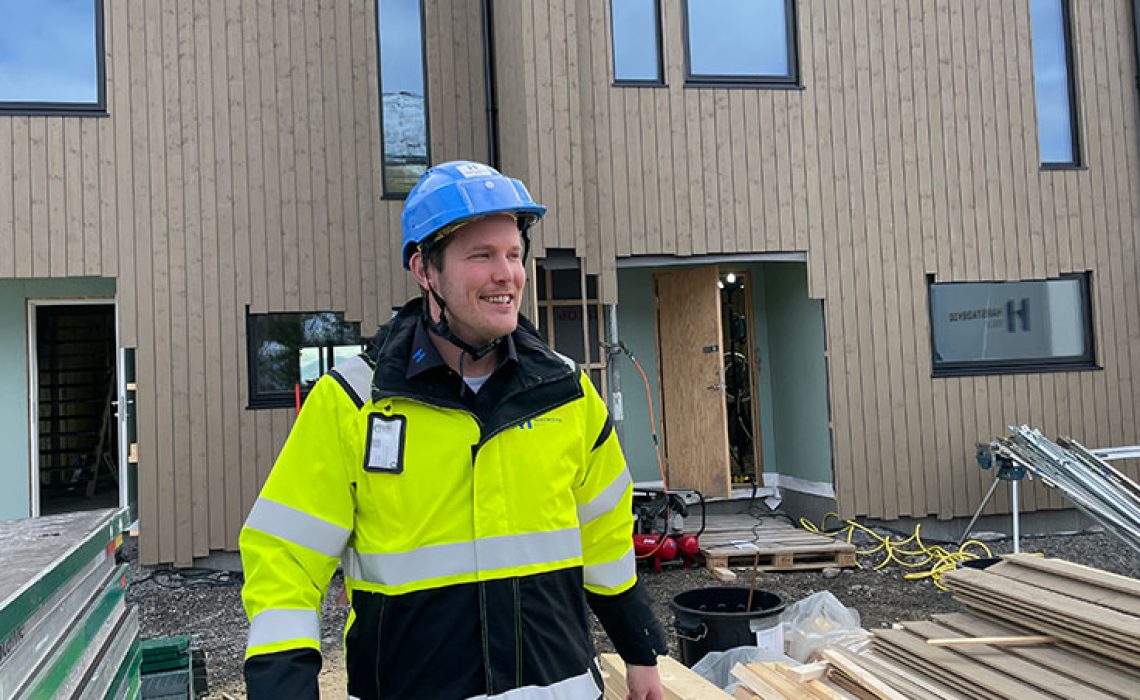 Bilde av mann med hjelm og arbeidsklær på en byggplass